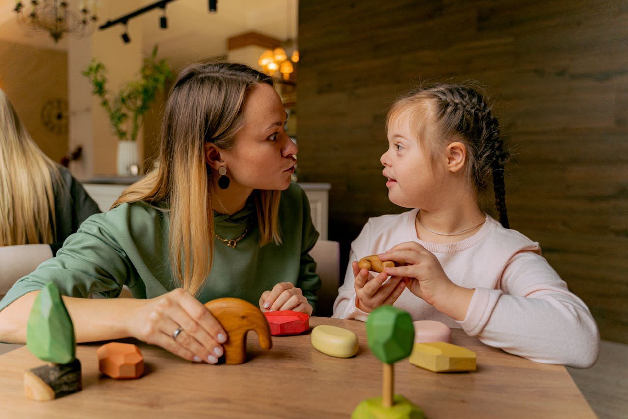 Frau und Kind mit Down-Syndrom beim Spielen
