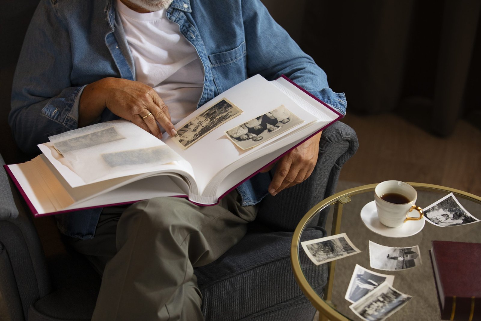 Älterer Mann schaut in ein Fotoalbum. Biographien bestimmen den Wunsch gemeinnützig zu vererben.