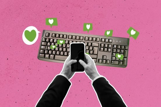 Tastatur mit grünen Herzen und zwei Händen, die ein Smartphone halten